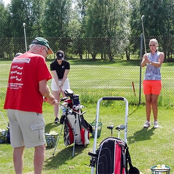 Ihmisiä golfaamassa.