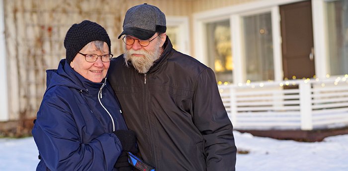 Sirkka ja Raimo Latvala seisovat kotitalonsa edessä.