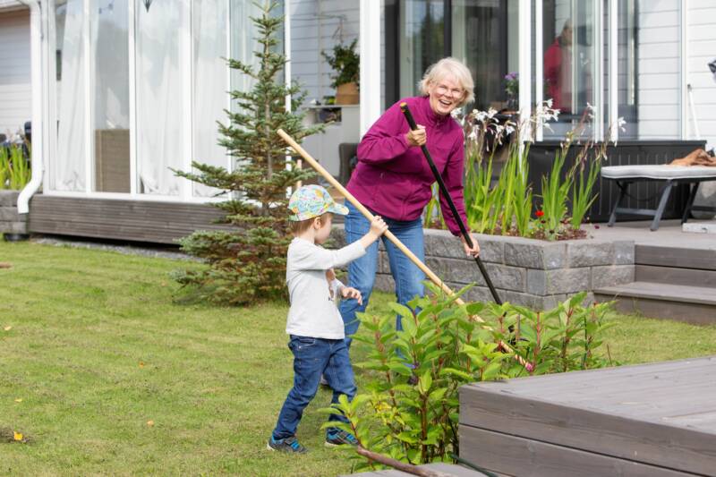 Nainen ja lapsi haravoivat